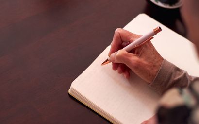 A person writing on a journal