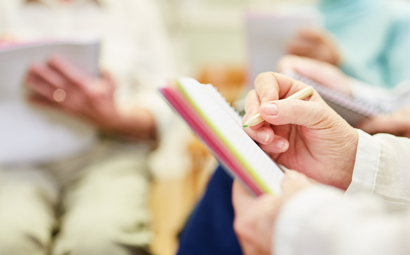 A group of people writing in notebooks