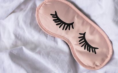 A sleep mask on white bedding